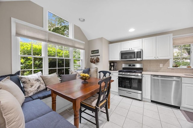2 Darby Pt Unit 2, Mashpee, MA 02649 - kitchen with appliances with stainless steel finishes, vaulted ceiling, light countertops, backsplash, and light tile patterned flooring
