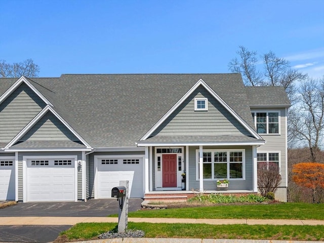 view of front of property with an attached garage, driveway, and a shingled roof