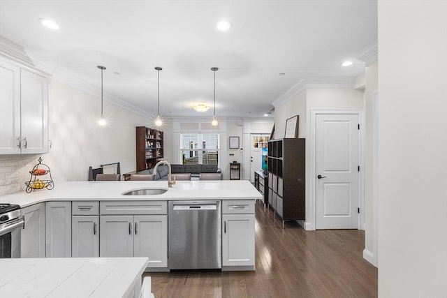 kitchen featuring a sink, stainless steel dishwasher, a peninsula, light countertops, and hanging light fixtures