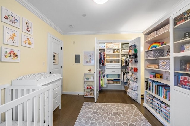 bedroom featuring ornamental molding, dark wood-style flooring, a closet, baseboards, and a walk in closet