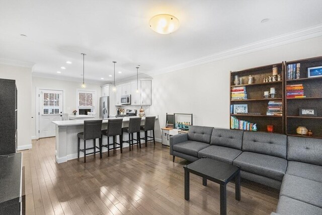 living room with dark wood finished floors, crown molding, recessed lighting, and baseboards
