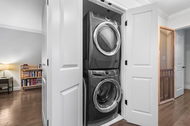 washroom with stacked washer / dryer, dark wood-type flooring, crown molding, and baseboards
