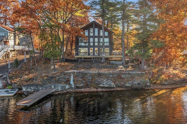 back of property with a balcony and a water view