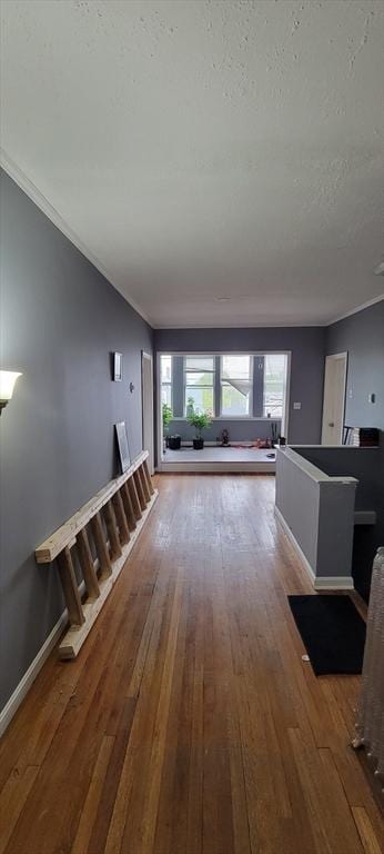 unfurnished living room featuring hardwood / wood-style flooring, crown molding, and a textured ceiling