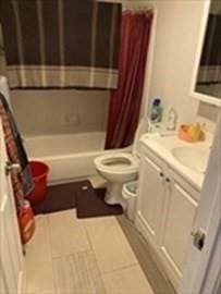 full bath featuring toilet, vanity, shower / bathtub combination with curtain, and tile patterned floors