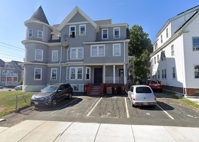 townhome / multi-family property featuring uncovered parking and a porch