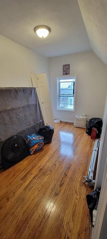bonus room featuring wood finished floors and vaulted ceiling