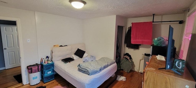 bedroom with wood finished floors and a textured ceiling