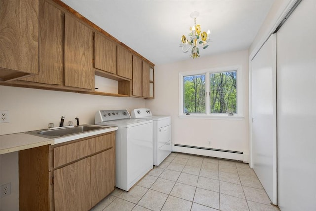 washroom featuring a baseboard heating unit, cabinet space, washing machine and dryer, a chandelier, and light tile patterned floors