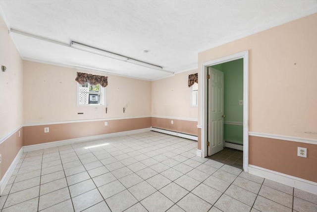 spare room with a baseboard heating unit, light tile patterned floors, and baseboards