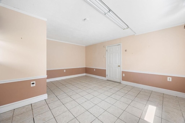 empty room with baseboards, light tile patterned floors, and ornamental molding