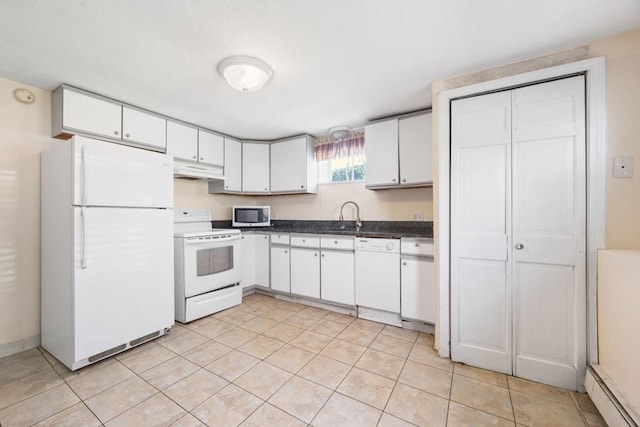 kitchen with white appliances, under cabinet range hood, dark countertops, and white cabinetry