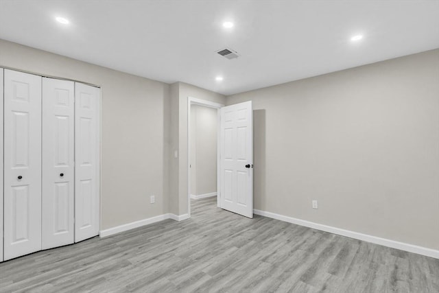 unfurnished bedroom featuring a closet and light hardwood / wood-style flooring