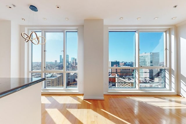 interior space with floor to ceiling windows, plenty of natural light, and light wood-type flooring