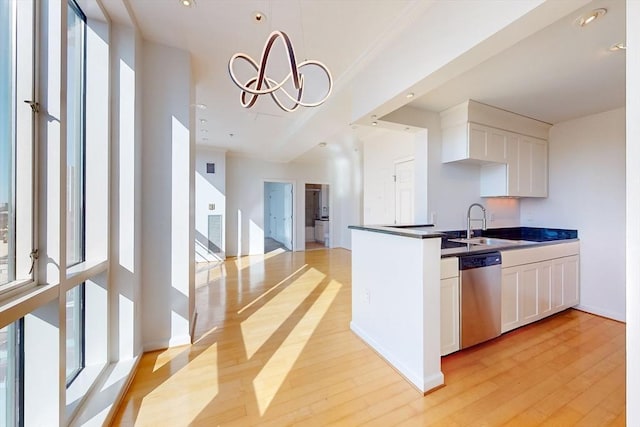 kitchen with sink, stainless steel dishwasher, a chandelier, light hardwood / wood-style floors, and white cabinets