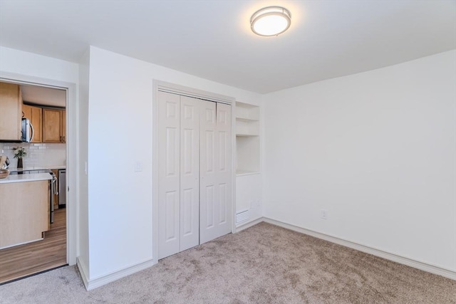 unfurnished bedroom with light carpet and a closet