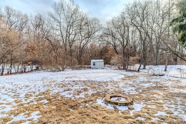 yard covered in snow featuring a storage shed