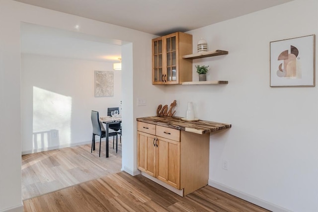 bar featuring light brown cabinetry and light hardwood / wood-style flooring