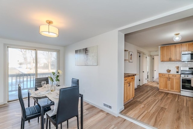 dining space with light wood-type flooring