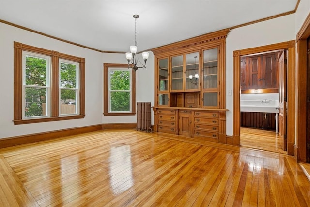 42 Middlesex St, Chelmsford, MA 01863 - unfurnished dining area with light wood-style flooring, a chandelier, radiator heating unit, crown molding, and baseboards