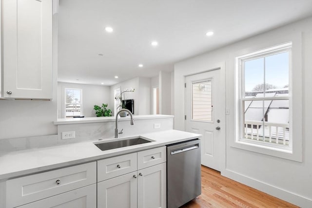 kitchen with white cabinets, a wealth of natural light, dishwasher, and sink