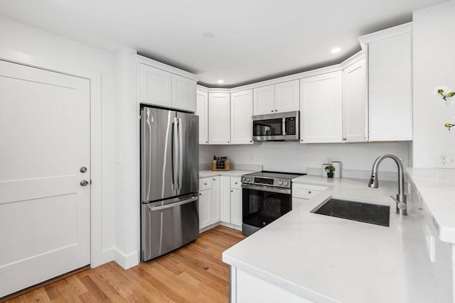 kitchen featuring white cabinets, light hardwood / wood-style floors, stainless steel appliances, and sink