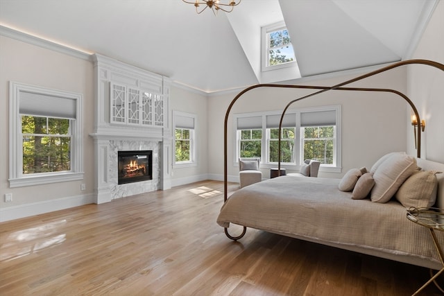 bedroom featuring ornamental molding, high vaulted ceiling, and light wood-type flooring