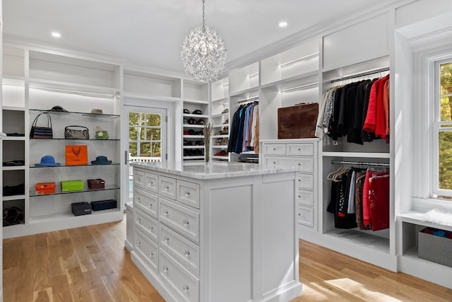 walk in closet featuring a notable chandelier and light wood-type flooring