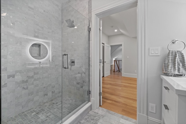 bathroom featuring vanity, a shower with shower door, and wood-type flooring