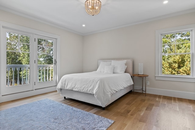 bedroom with multiple windows, ornamental molding, access to exterior, and wood-type flooring