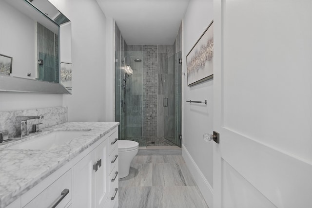 bathroom featuring vanity, toilet, and an enclosed shower