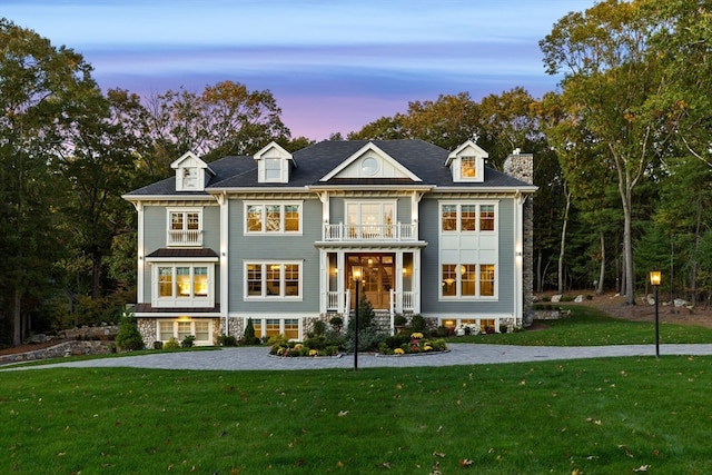 view of front of home featuring a balcony and a lawn