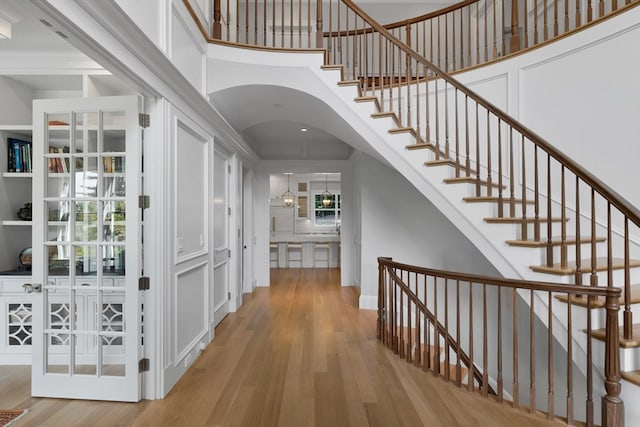 interior space with ornamental molding, a high ceiling, and light hardwood / wood-style floors