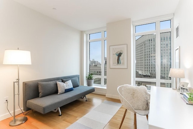 sitting room featuring baseboards, plenty of natural light, light wood finished floors, and visible vents