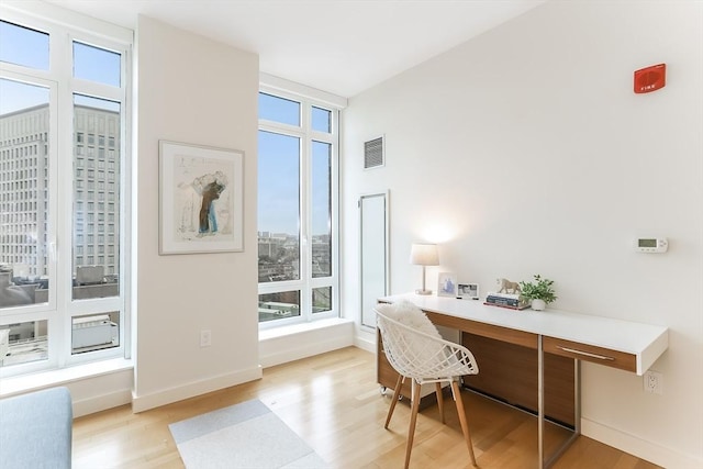 office area featuring baseboards, visible vents, and light wood finished floors