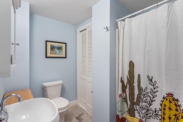 bathroom featuring toilet, sink, and walk in shower