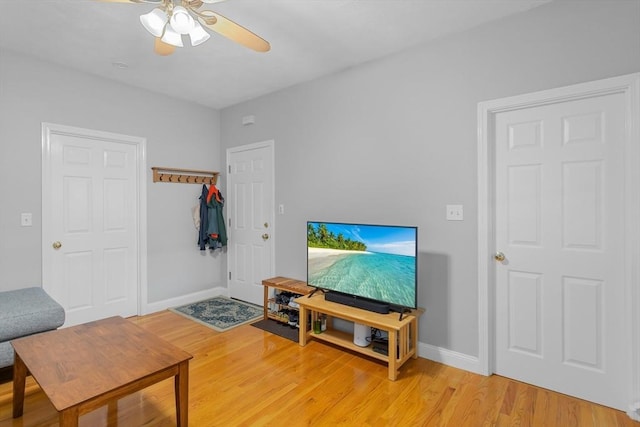 living room featuring light hardwood / wood-style flooring and ceiling fan