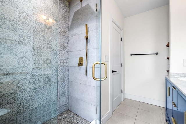 full bath featuring tile patterned floors, a stall shower, vanity, and baseboards