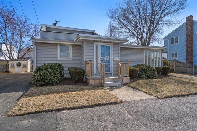 view of front of property with aphalt driveway and fence