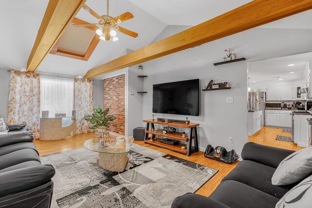 living room with light hardwood / wood-style flooring, ceiling fan, and vaulted ceiling with beams