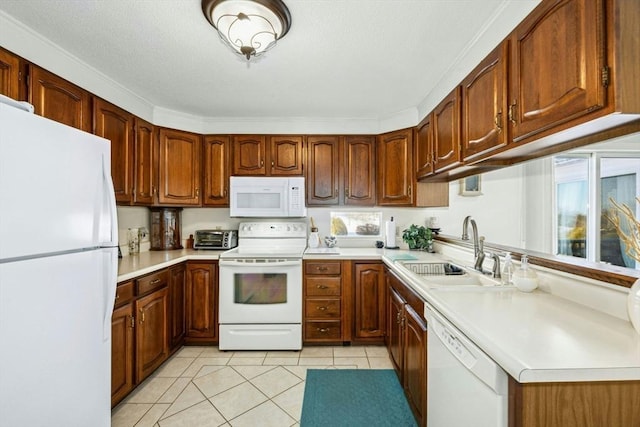 kitchen featuring white appliances, light tile patterned floors, brown cabinets, light countertops, and a sink