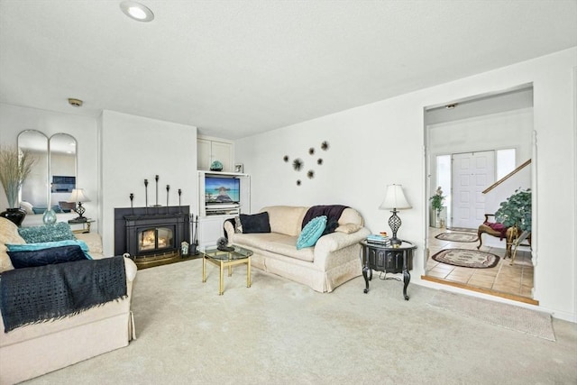 living room with a lit fireplace and carpet floors