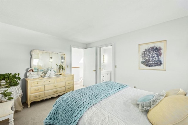 bedroom with ensuite bathroom and light colored carpet