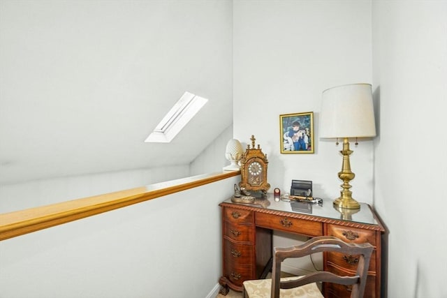 office space featuring lofted ceiling with skylight