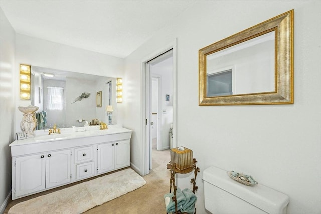 full bath featuring toilet, vanity, and baseboards