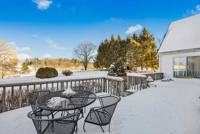 snow covered deck featuring outdoor dining area