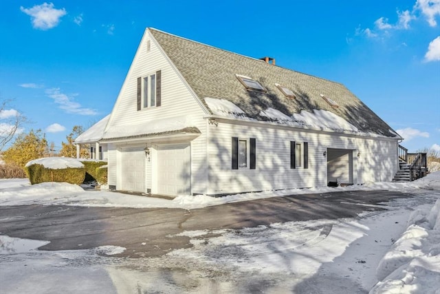 view of snowy exterior featuring roof with shingles