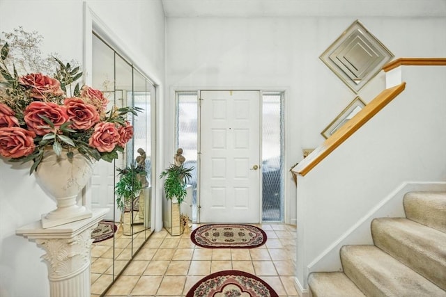 entryway featuring light tile patterned flooring and stairs