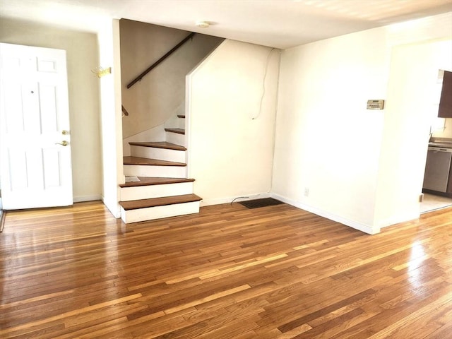 interior space featuring baseboards, stairs, and wood finished floors