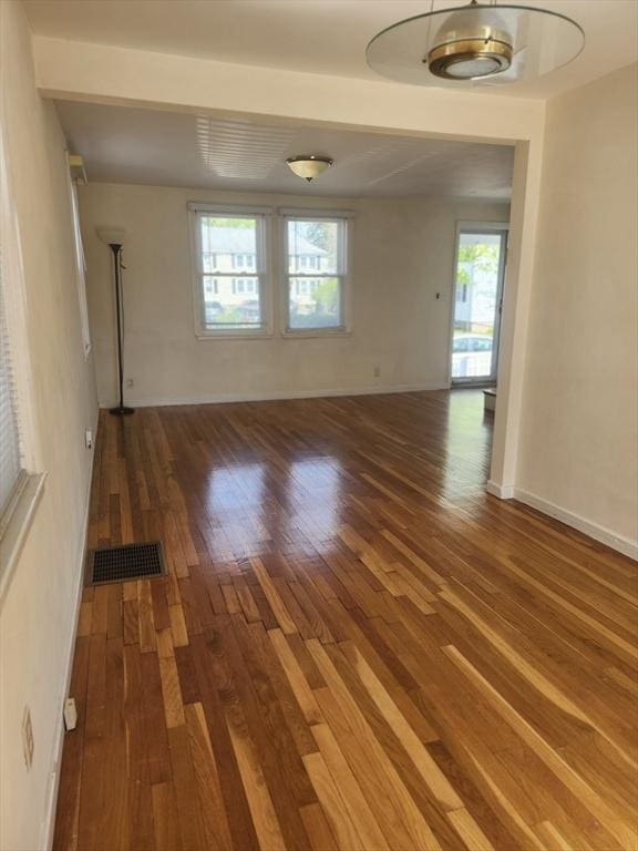 unfurnished room with visible vents, baseboards, and wood finished floors